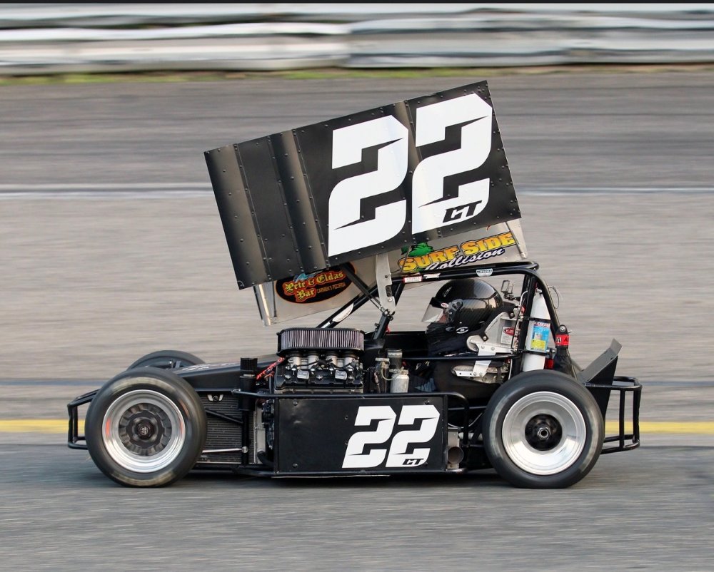 The number 22 CT three-quarter midget race car on track at speed